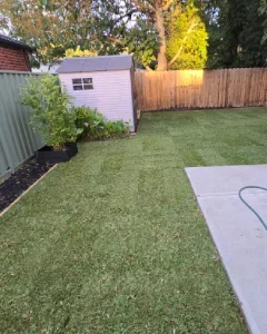 Landscaper completing hands-on outdoor surface work with direct client communication